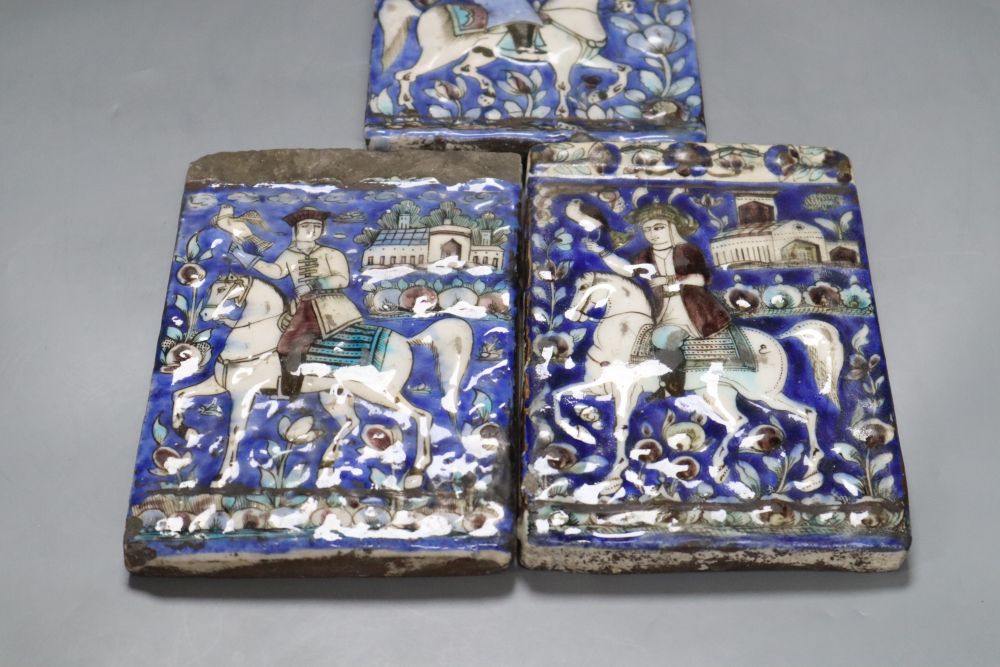 Three Persian pottery wall tiles, Qajar dynasty, relief-moulded with falconers on horseback, each approx 19 x 12.5cm